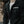 Person wearing a black jacket with 'Hollow Head Threads' label, blurred background